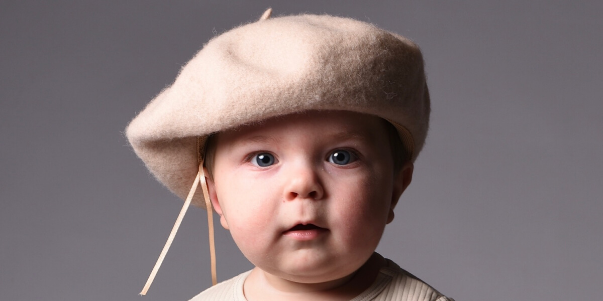 Närbild på bebis med beige basker i fotostudio